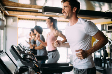 row of people running on treadmills