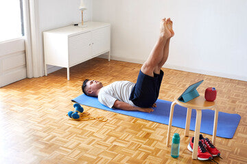 man on yoga mat working out at home