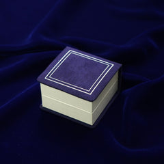 A dark blue and white Automic Gold ring box closed to show the velvet lid