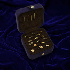 An open Automic Gold Travel Case with multiple pieces of solid gold jewelry inside and chains tucked into the pouch on top