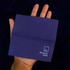 An Automic Gold jewelry polishing cloth laid out on a model's palm