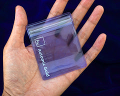 A model holding an Automic Gold storage pouch in the palm of their hand