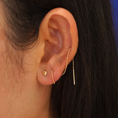 Close up view of a model's ear wearing an Circle Threader wrapped around their ear through three piercings