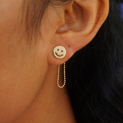 Close up view of a model's ear wearing a yellow gold Connector with both attached behind a Smiley Face Earrings