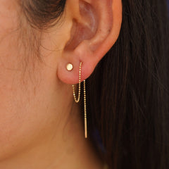 Close up view of a model's ear wearing a Circle Threader looped through two piercings