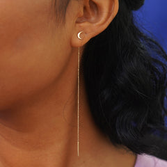 A model's ear wearing a Moon Earring with an Extender attached at the back and dangling down to their shoulder