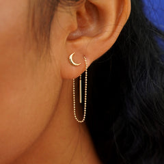 A models ear wearing a Moon Earring with an Extender attached at the back and threaded through the front of a second piercing