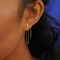A model's ear wearing a Moon Earring with an Extender attached at the back and threaded forward through a second piercing