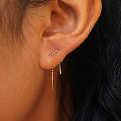 Close up view of a model's ear wearing a Mini Threader across two piercings