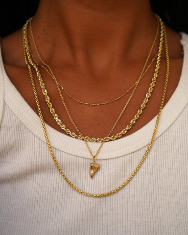 A model wearing various Automic Gold chains