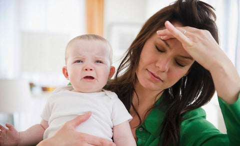 Upset mother comforting her upset baby during toddler sleep regression.