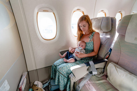 Mother and baby traveling on an airplane, highlighting traveling with an infant.