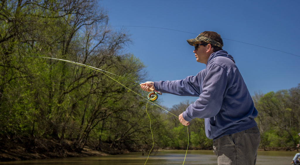 Fly fisherman using a spinning reel with yellow line in a close up