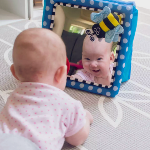 Infant Smilig back to his reflection in the mirror | Fun playtime ideas