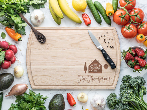 Engraved wooden cutting board with produce around it.
