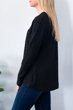 Our best selling waffle knit top is now available in Black.  Whether your lounging or it's a casual day, you'll love our Waffle Knit Long Sleeve Top in Black. This super soft waffle knit top features long sleeves, split neckline with grommet detailing, and a front bust pocket.  Perfect for pairing with leggings and sneakers.