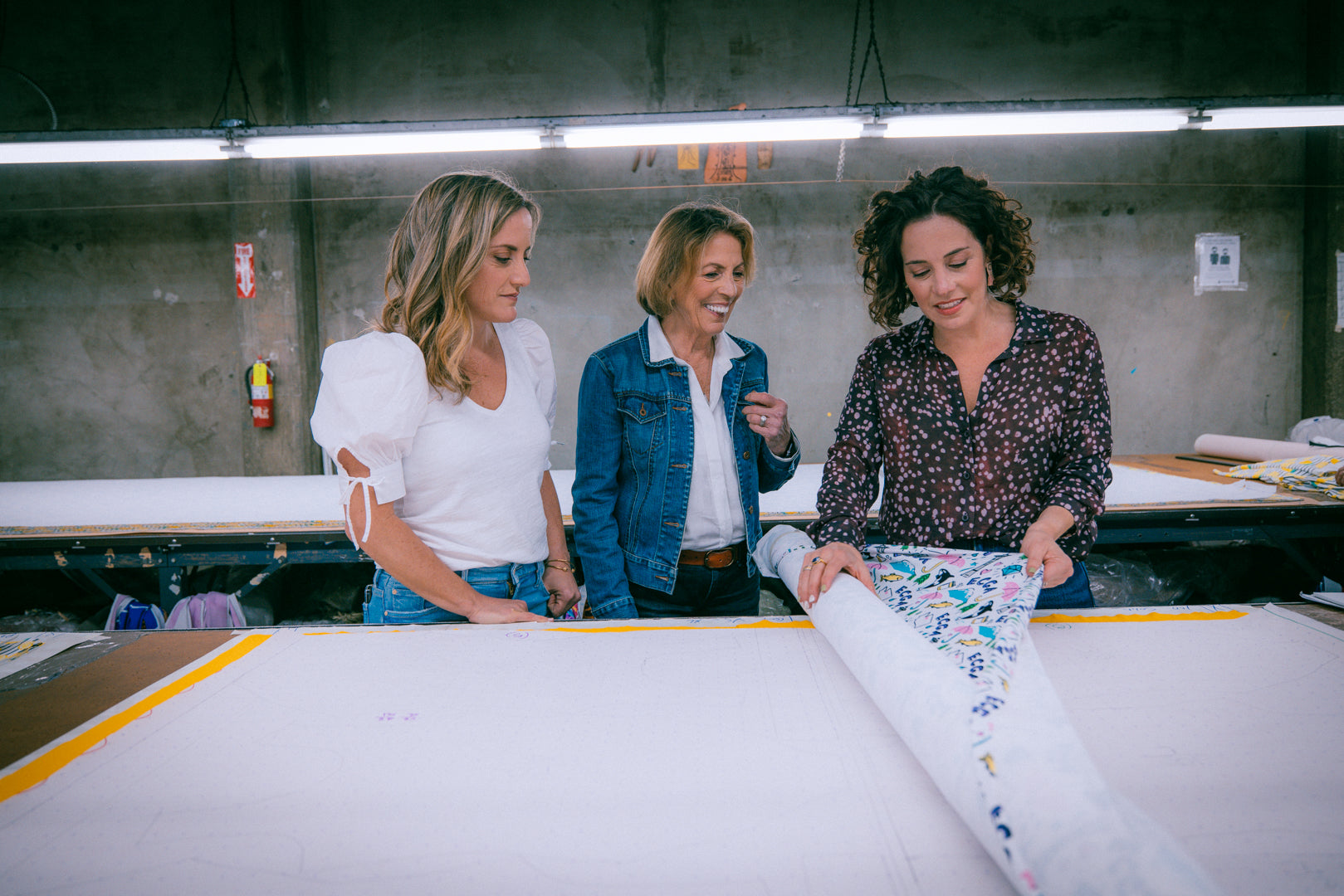 Jen, Jodi, and Donna inspect fabric for new gymnastics leotards, Destira, 2023
