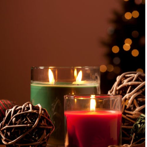 Christmas candles with a Christmas tree behind