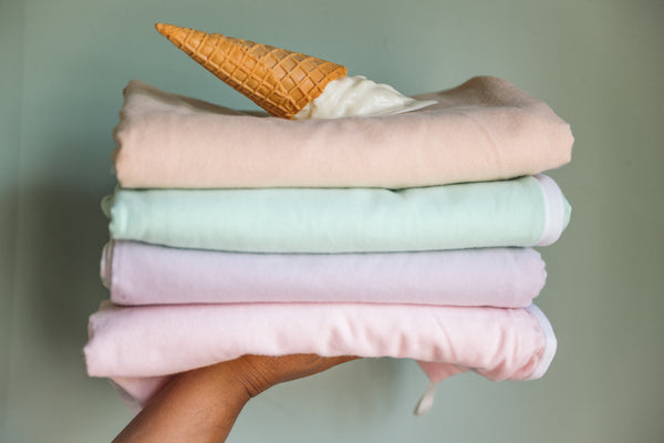 Solid towels being held by a hand with an ice cream on top