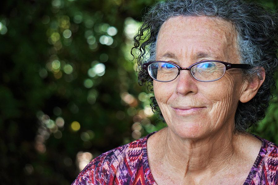 An older woman is smiling at the camera