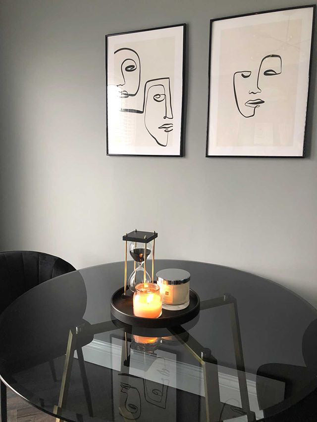 Black glass dining table with lit candles on tray