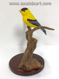 Goldfinch is a hand painted wood carving with mixed media by Jim Carpenter.