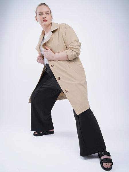 See ROSE Go water repellant trench coat great for travel on blond model with black multitasker wide leg pants. 