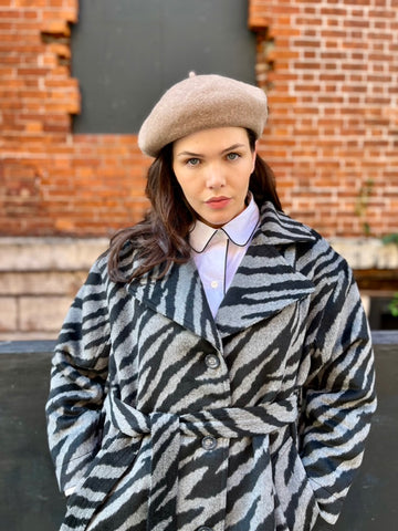 See ROSE Go plus size trench coat in black and gray zebra pattern, close up on model showing belt tied at the front