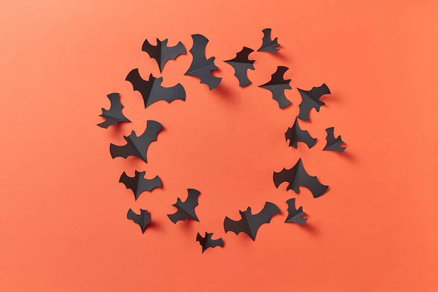 decorazioni pipistrelli di carta halloween su fondo arancione