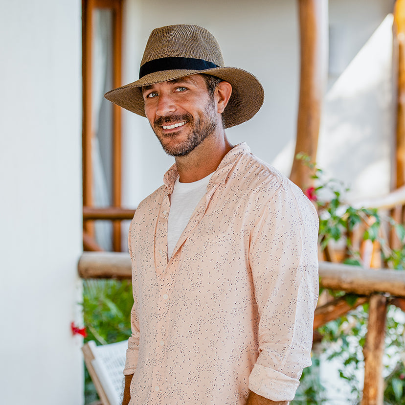 Man standing relaxed on a jungle path Wearing a Carkella Parker Fedora Poly-straw Fedora Sun Hat with hands at his side