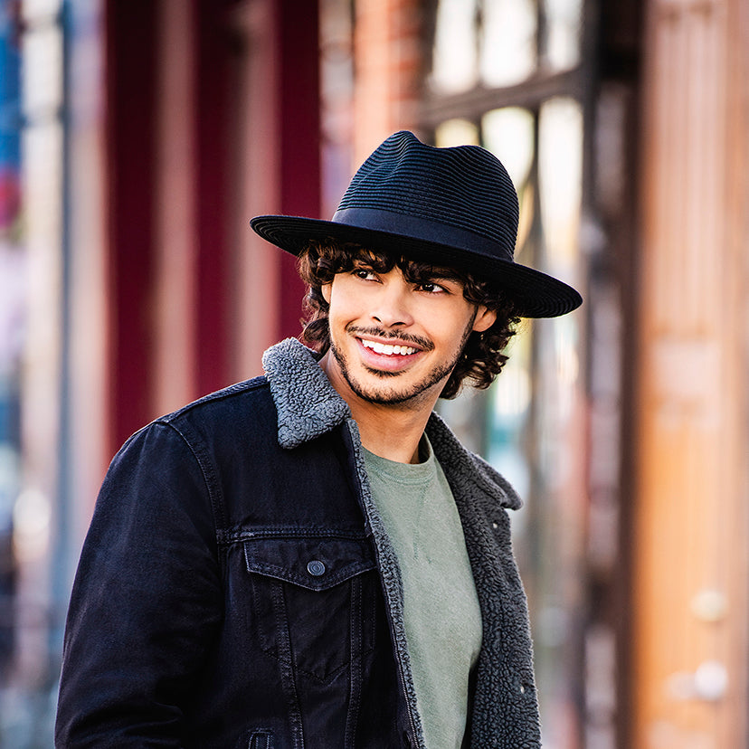 Man standing and smiling on a city street Wearing a Carkella Palm beach sun cap 