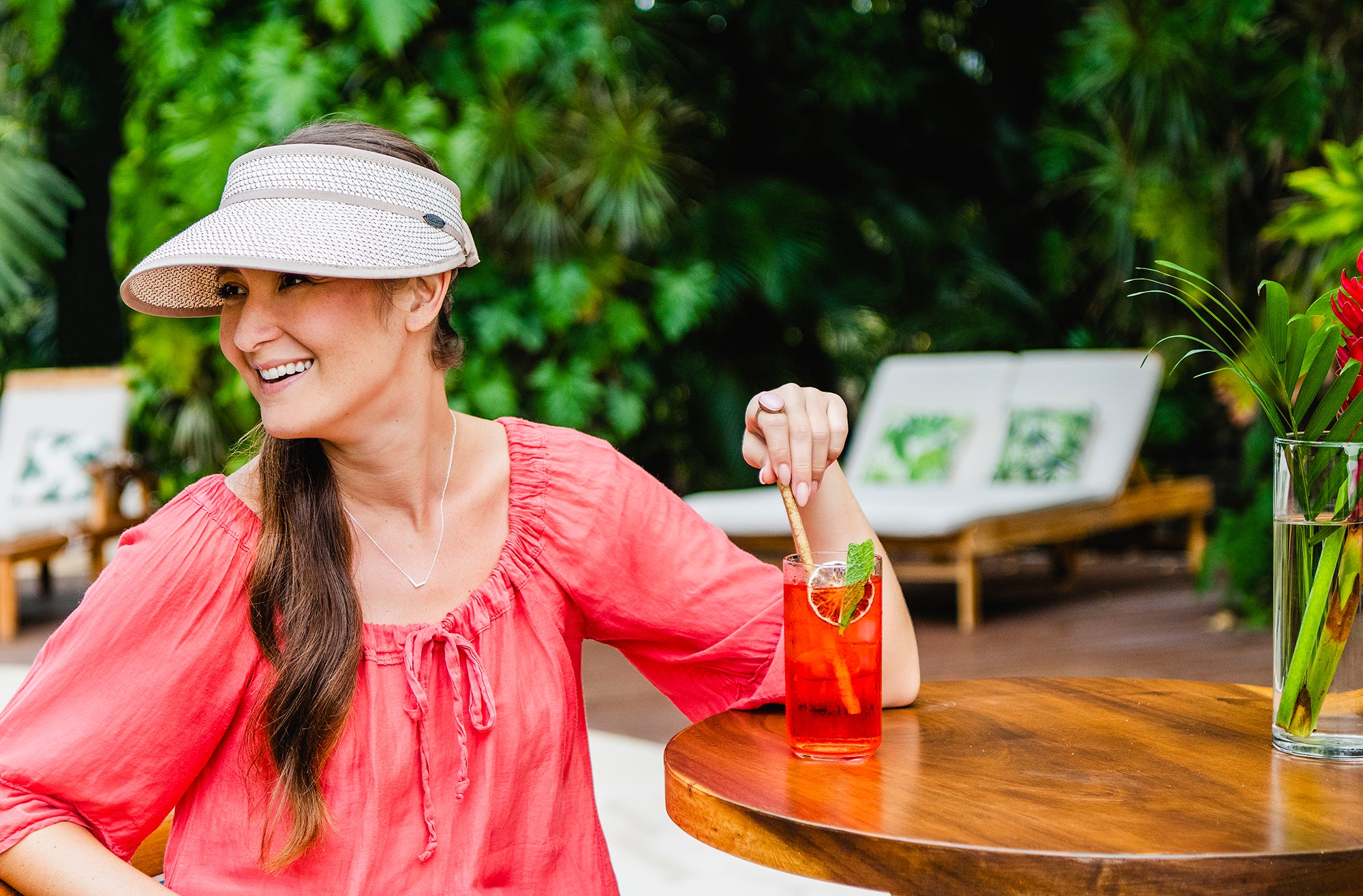 Woman sitting by the pool wearing the Charlie sun visor by Wallaroo