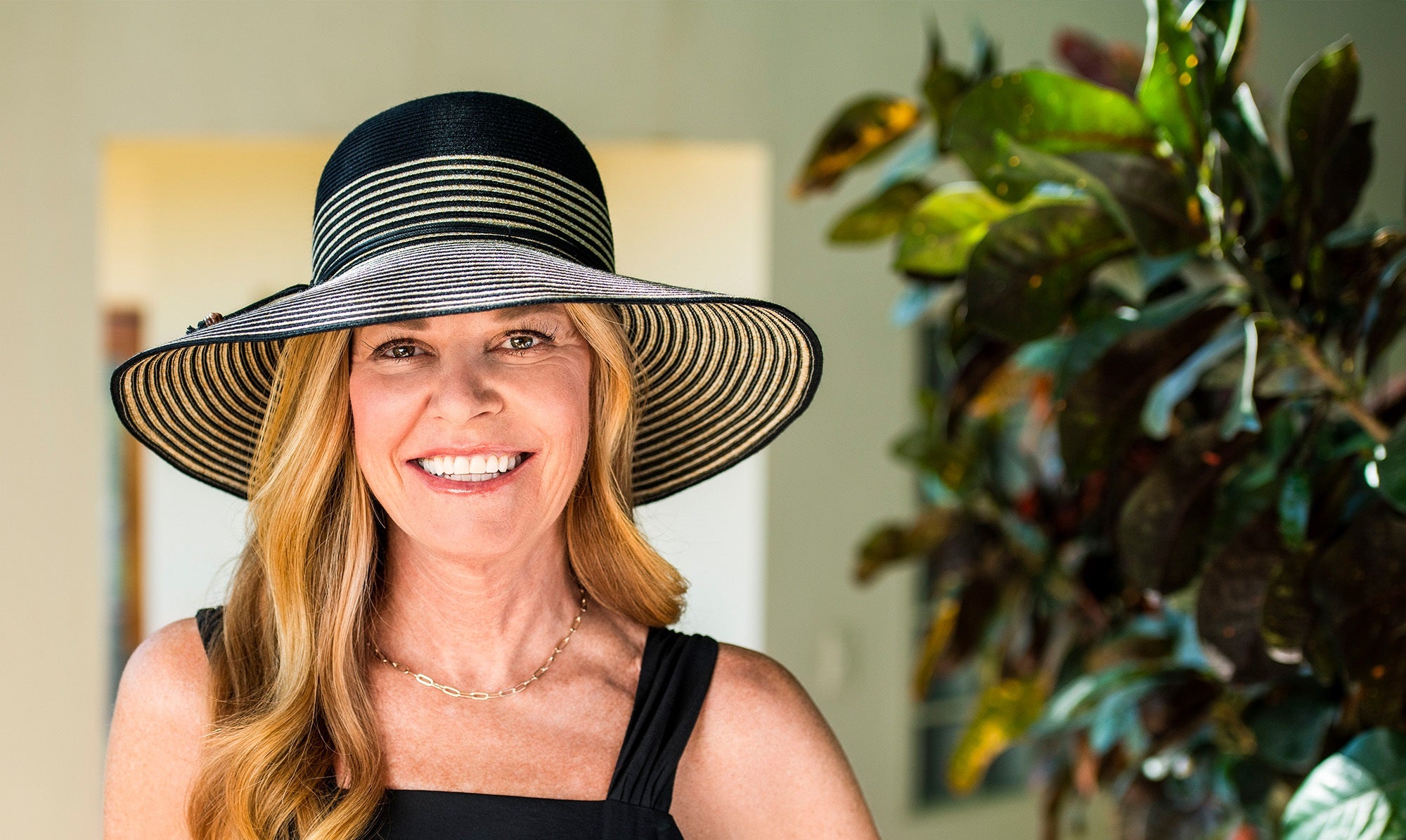 Woman Smiling while Wearing a Wallaroo Marseille summer Sun Hat in a Garden