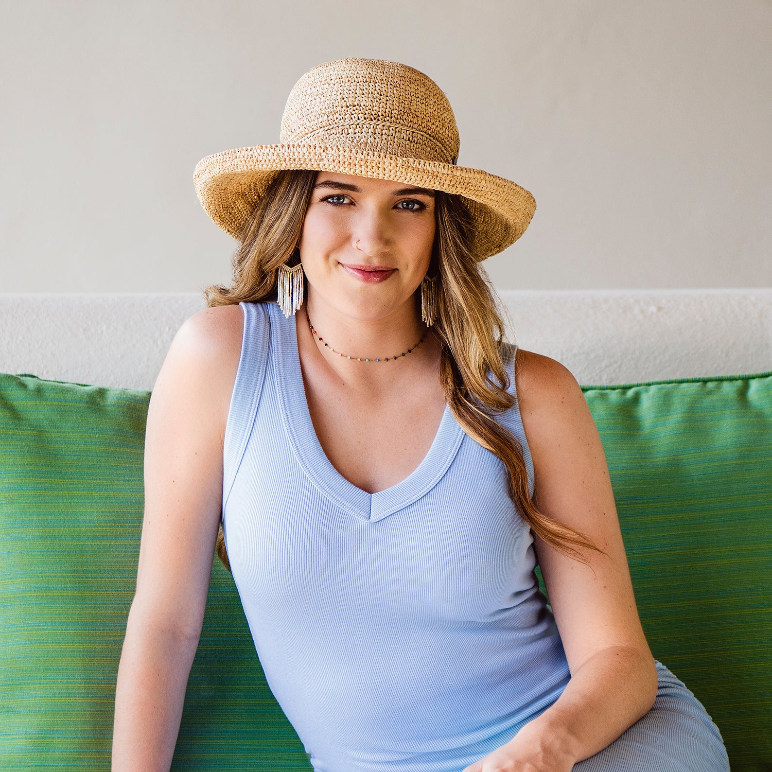 Woman Wearing a Petite Catalina Straw Beach Hat while sitting