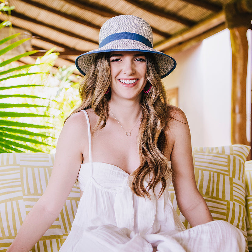 Woman on couch sitting while wearing the Petite Darby bucket style summer sun hat