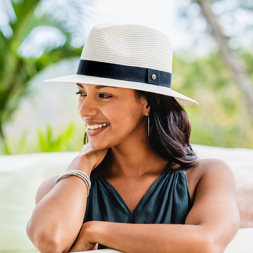 Woman outside wearing the petite palm beach summer sun hat by Wallaroo, with a UPF 50+ rating
