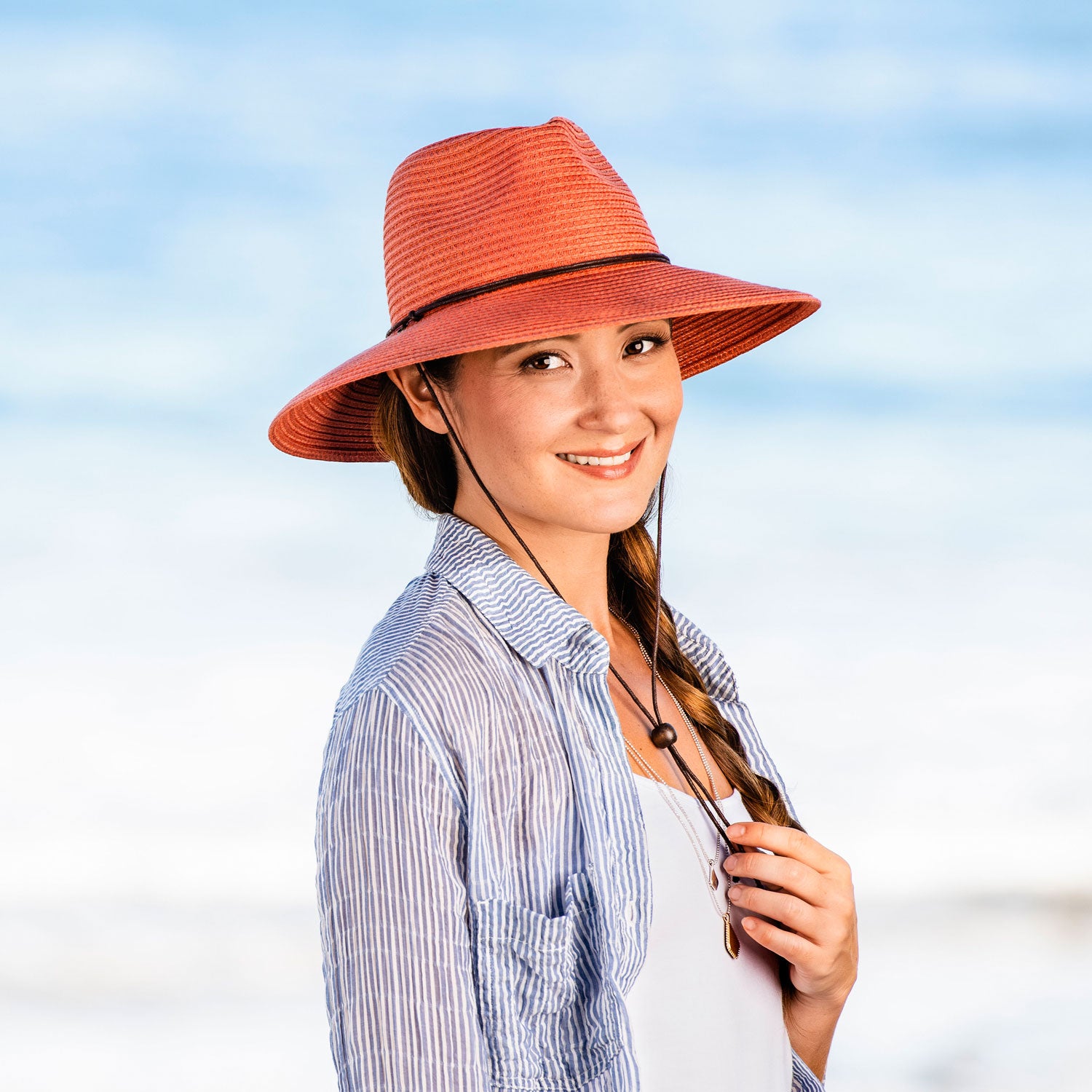 Woman Wearing a Wallaroo Petite Sanibel Summer Sun Hat with uv protection while on the beach