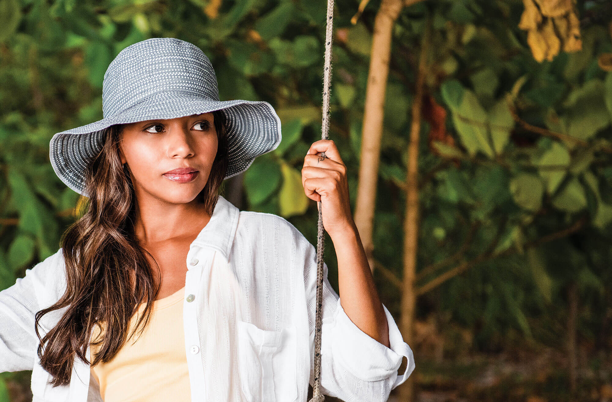 Woman on a Swing Wearing a Wallaroo Petite Scrunchie Summer Sun Hat, with uv protection