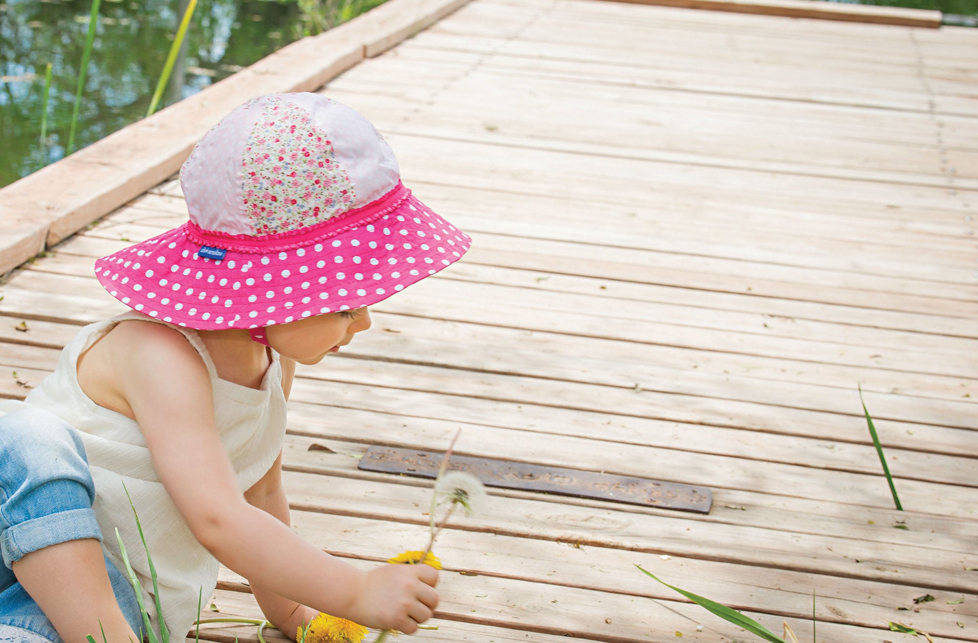 Child Picking Flowers Wearing a Wallaroo Platypus Cotton Sun Hat with Chinstrap