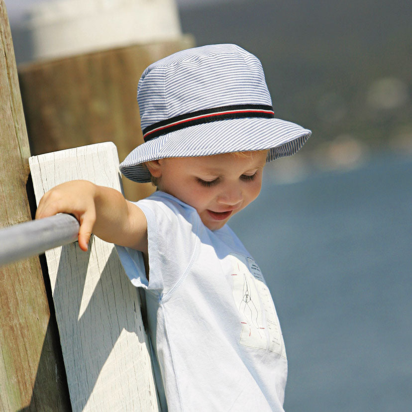 Child Wearing a Wallaroo Sawyer Cotton Sun Hat while on a Bridge