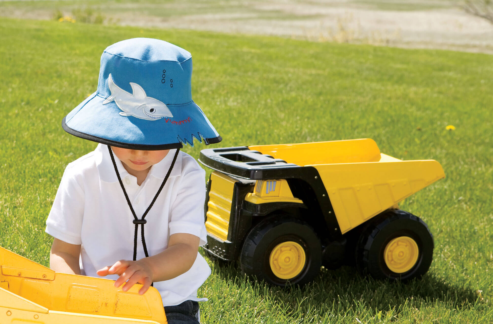 Boy Wearing a Wallaroo Shark Hat Cotton Sun Hat with Chinstrap while Playing with a Toy
