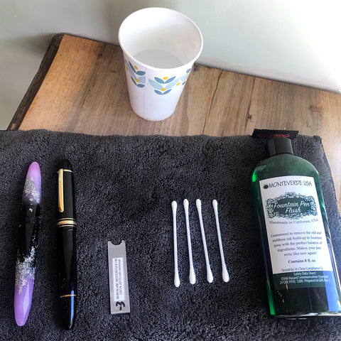 pens to be cleaned, nib removal tool, Q-tips, small cup of water, fountain pen flush; optional: silver polish