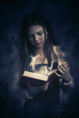 girl reading book with magic coming out of it