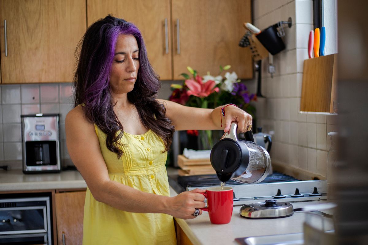 Woman making herself a cup of tea.