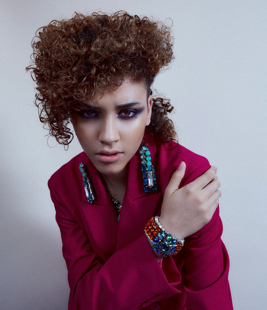 A model wearing Jolita Jewellery's statement earrings and colourful crystal bracelet