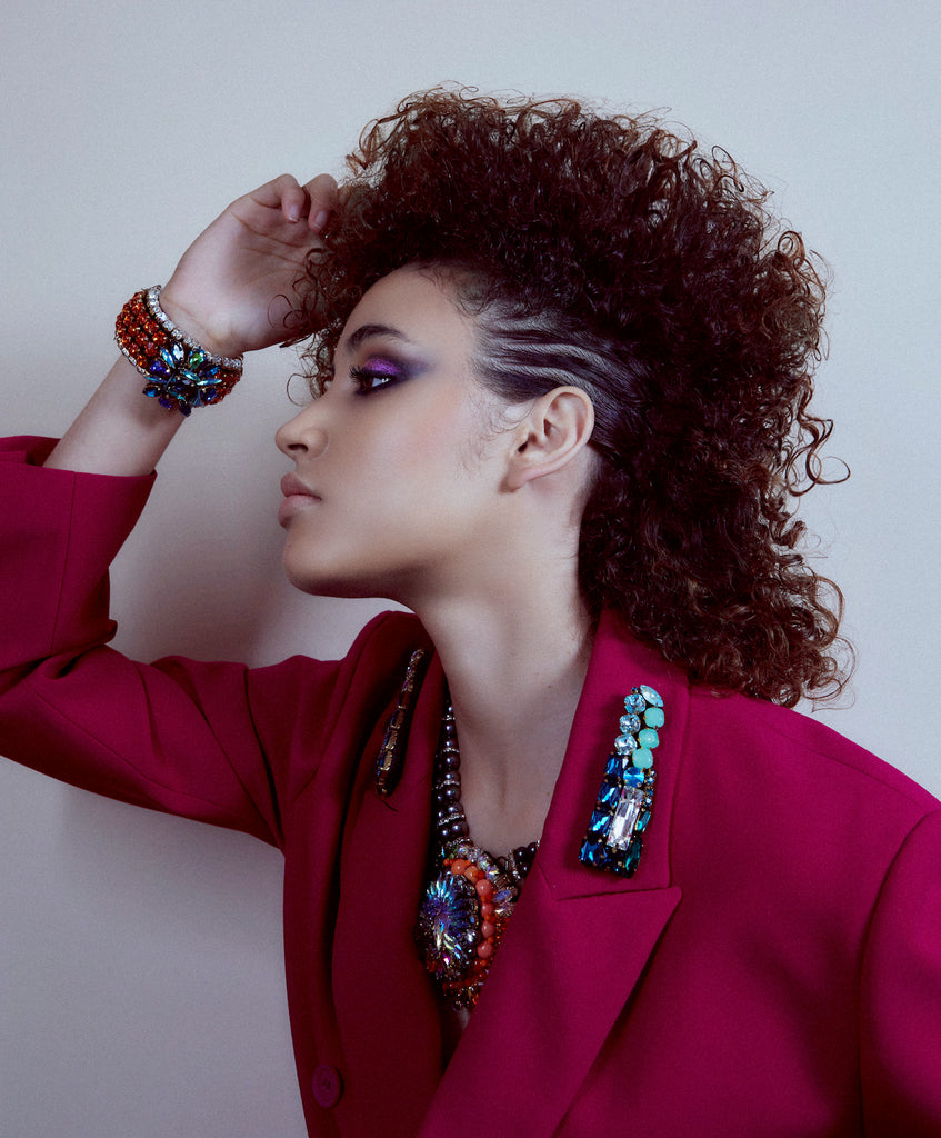 A model wearing Jolita Jewellery's statement earrings, crystal and pearl pendant necklace and colourful crystal bracelet