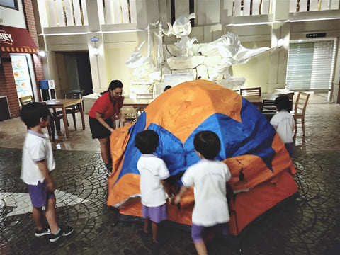 Working together to pitch tents indoors