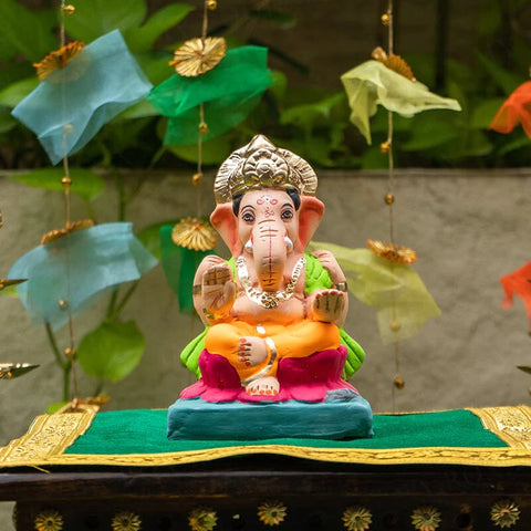 lord ganesha idol in yellow dhoti.