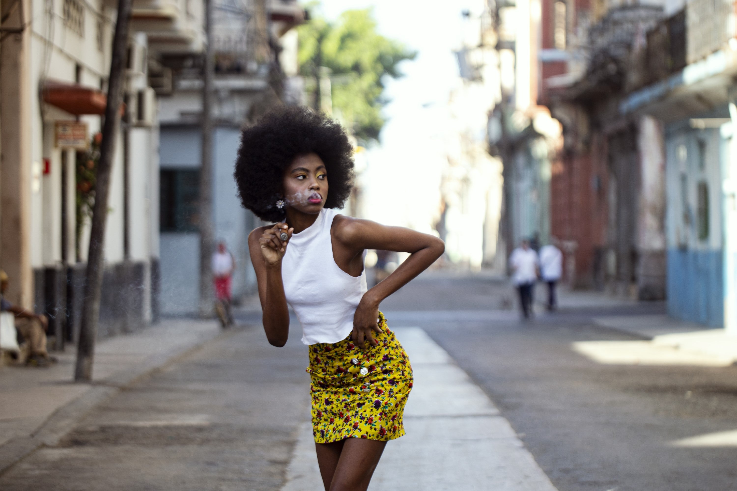 A Havana resident finds time for a Cuban cigar in a deserted Havana street.