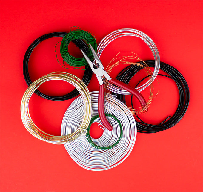 a pair of pliers on top of various types of wire